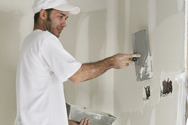 Drywall finisher spackling a wall